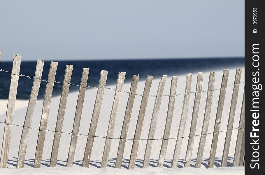 A fence on a white sandy beach in Orange Beach AL. A fence on a white sandy beach in Orange Beach AL.