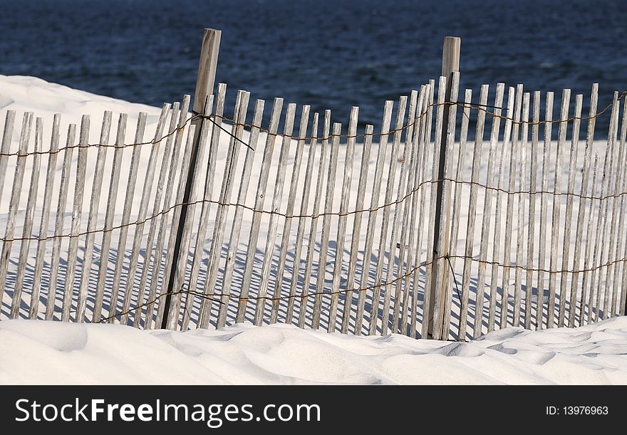 A fence on a white sandy beach in Orange Beach AL. A fence on a white sandy beach in Orange Beach AL.