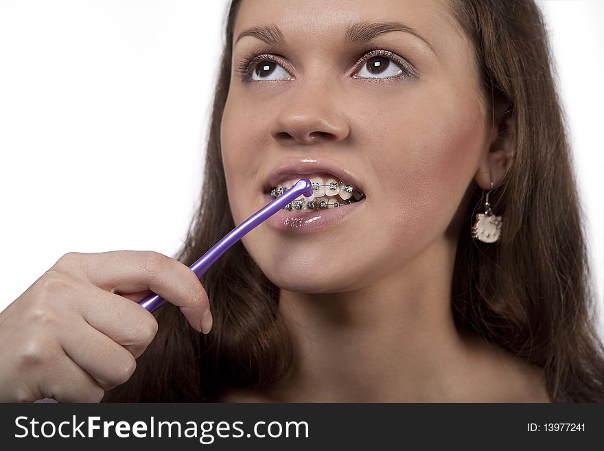 Teeth and bracket system cleaning procedure using round toothbrush standing isolated over white background. Teeth and bracket system cleaning procedure using round toothbrush standing isolated over white background