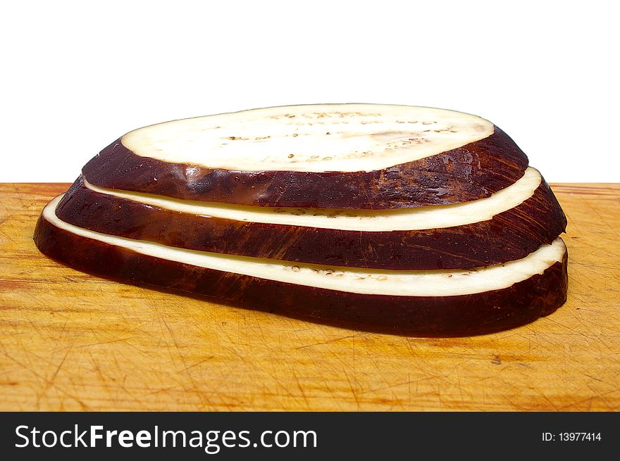 Purple egg plant aubergine on wooden board