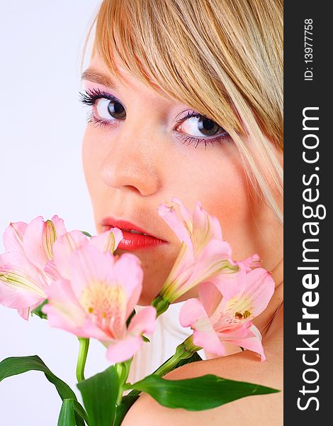 Portrait of a woman holding pink flowers over white background