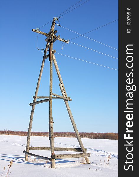 Wooden electric base, decrepit from old age, standing in the open field. Wooden electric base, decrepit from old age, standing in the open field