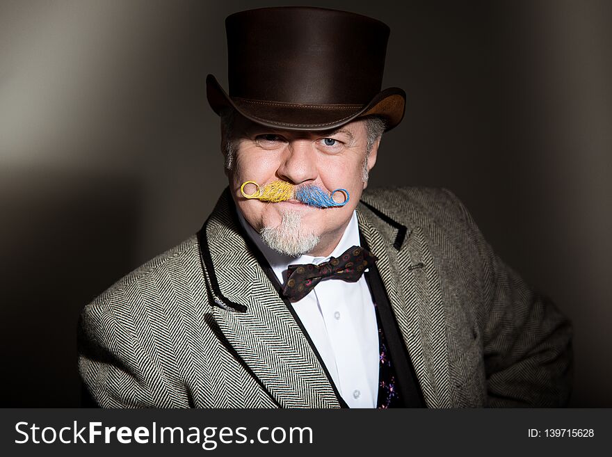 Mustache is an adult male artist in a business suit and a cylinder hat.