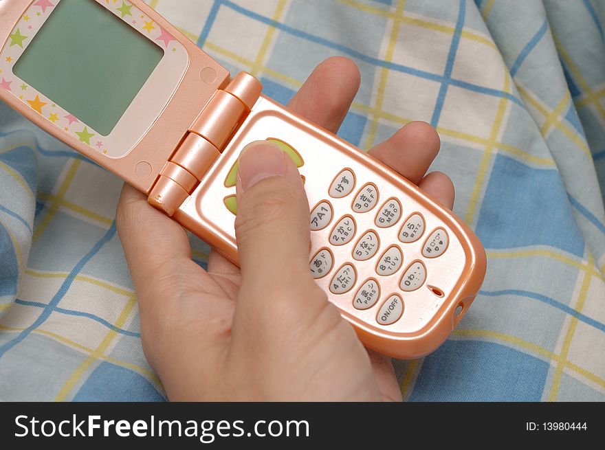 A feminine mobile phone in the hand, the keyboard with Japanese symbol.