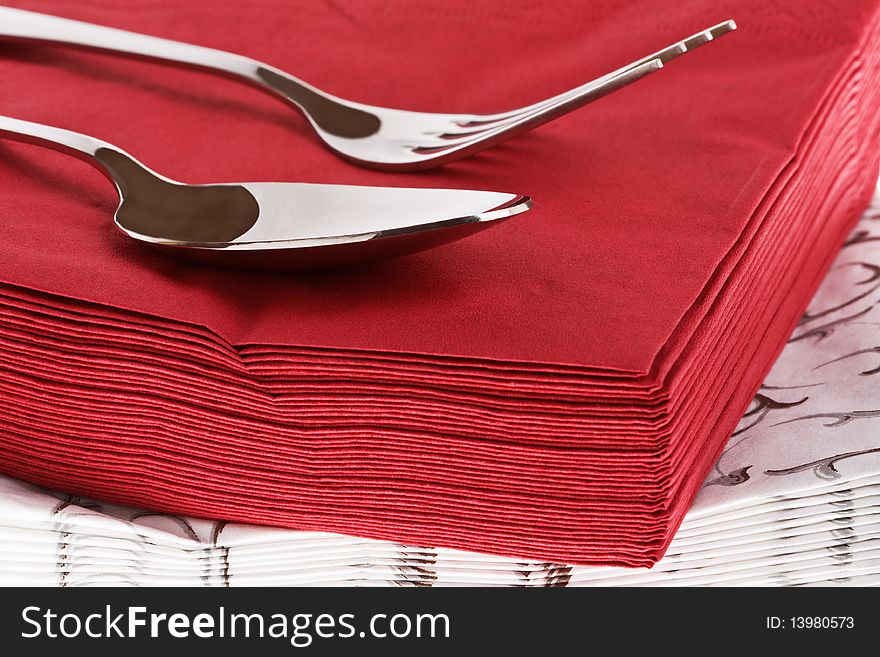 Silvery fork and spoon on red napkin. Silvery fork and spoon on red napkin