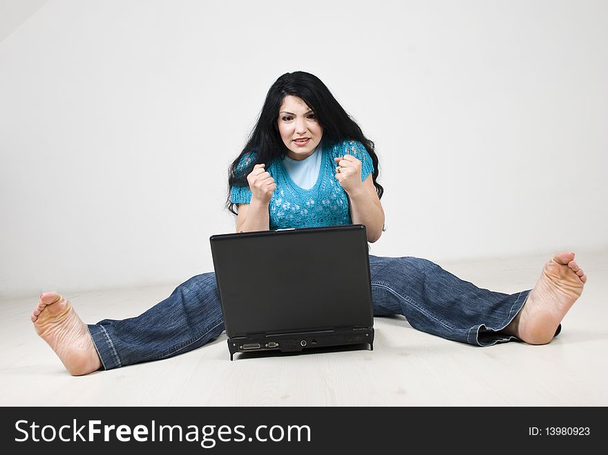 Stressed woman expecting something on her laptop or hoping to not crash and sitting on floor with all body strained.Check also Facial expressions and gesture. Stressed woman expecting something on her laptop or hoping to not crash and sitting on floor with all body strained.Check also Facial expressions and gesture