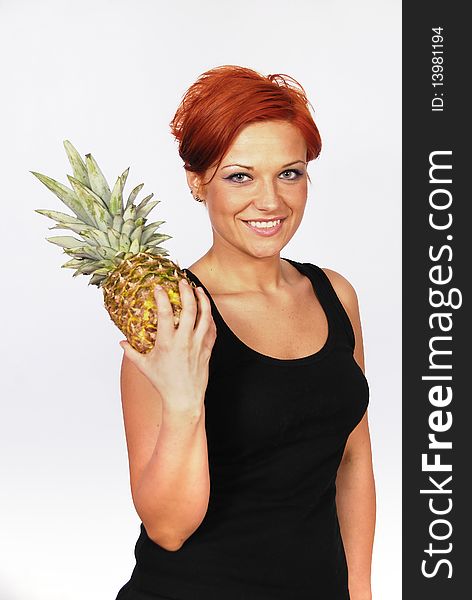 Smiling girl with pineapple in the hand on the white background