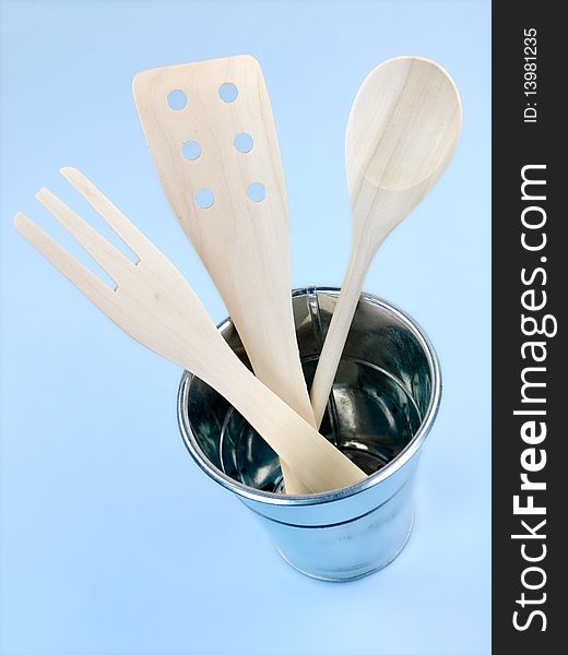 Wooden kitchen utensils isolated against a blue background
