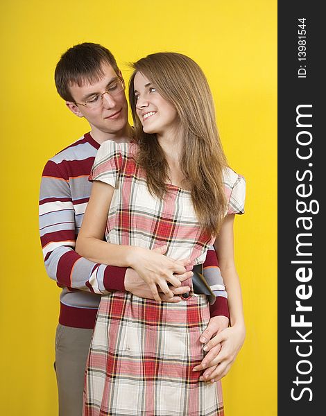 Young happy couple on light yellow background. Young happy couple on light yellow background