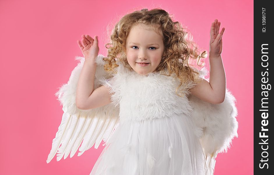 Beautiful little angel girl isolated on pink background