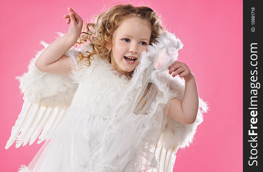 Beautiful little angel girl isolated on pink background