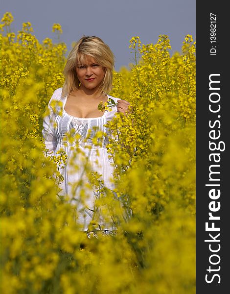 Beautiful blond Girl in the blossom Field to white dressed. Beautiful blond Girl in the blossom Field to white dressed