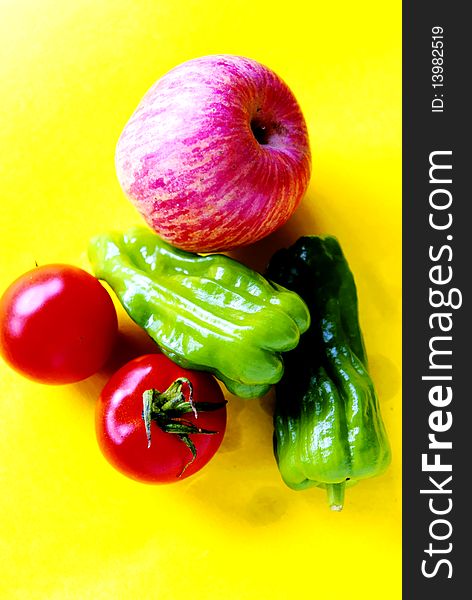 Apple and vegetables on yellow background