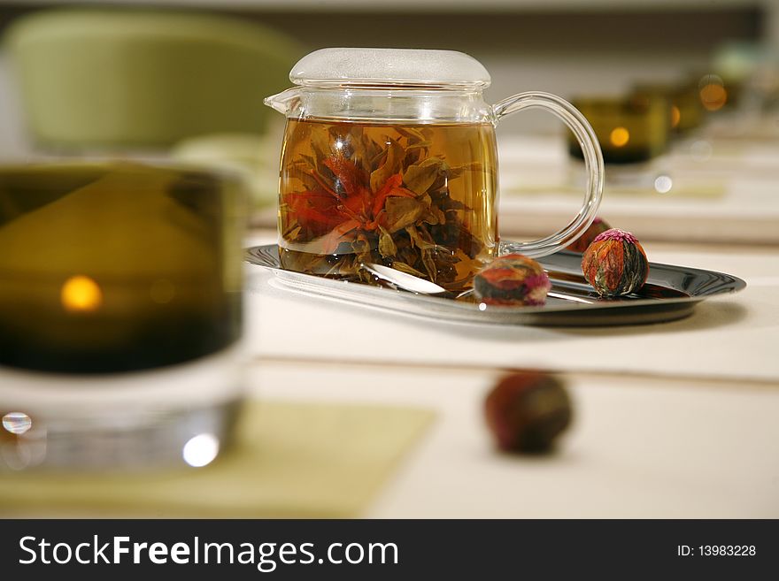 Glass tea pot with fresh green tea standing on an iron tray horizontal