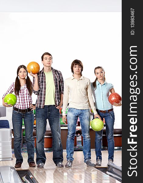 Four young people with spheres in bowling. Four young people with spheres in bowling