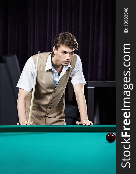 The young attractive man plays billiards. The young attractive man plays billiards