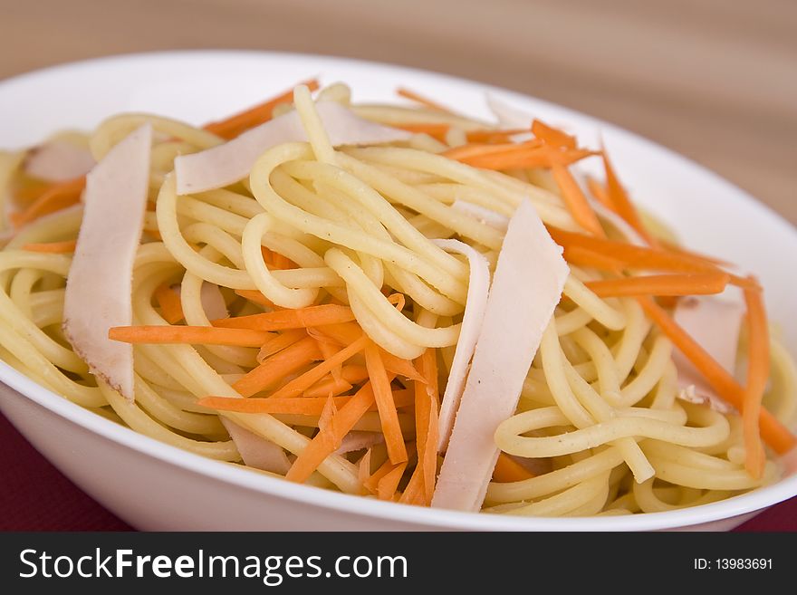 Pasta salad in a bowl with carrot and meat. Pasta salad in a bowl with carrot and meat