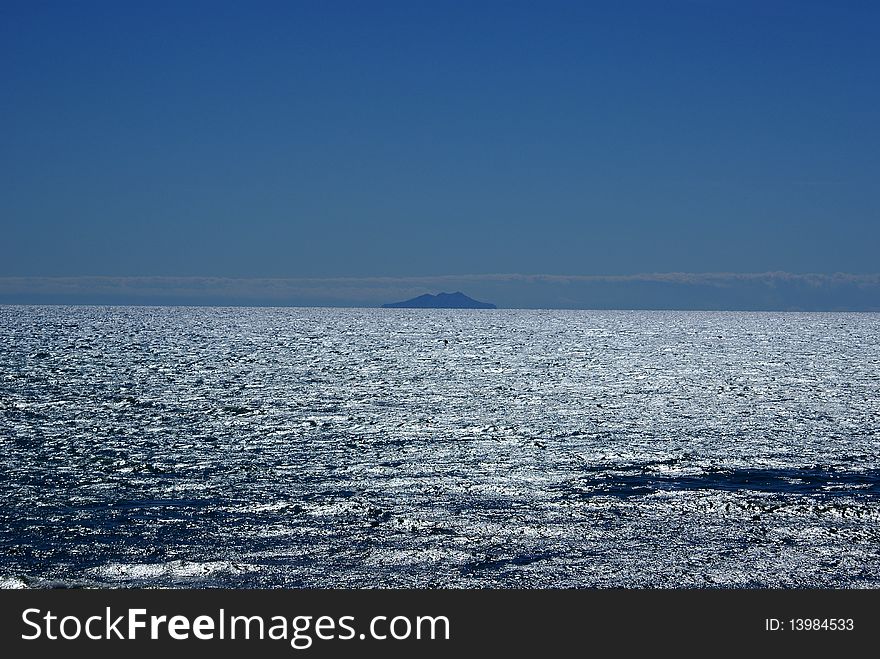 Giglio Island looks like a mirage on the horizon, in the Tyrrhenian Sea. Giglio Island looks like a mirage on the horizon, in the Tyrrhenian Sea.