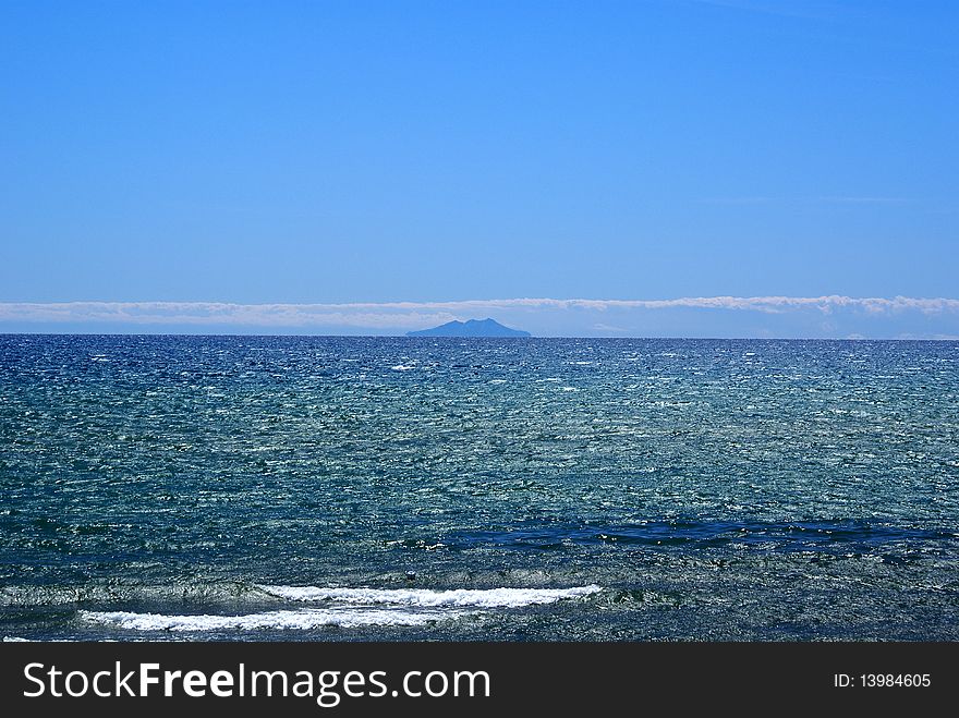 Giglio Island looks like a mirage on the horizon, in the Tyrrhenian Sea. Giglio Island looks like a mirage on the horizon, in the Tyrrhenian Sea.