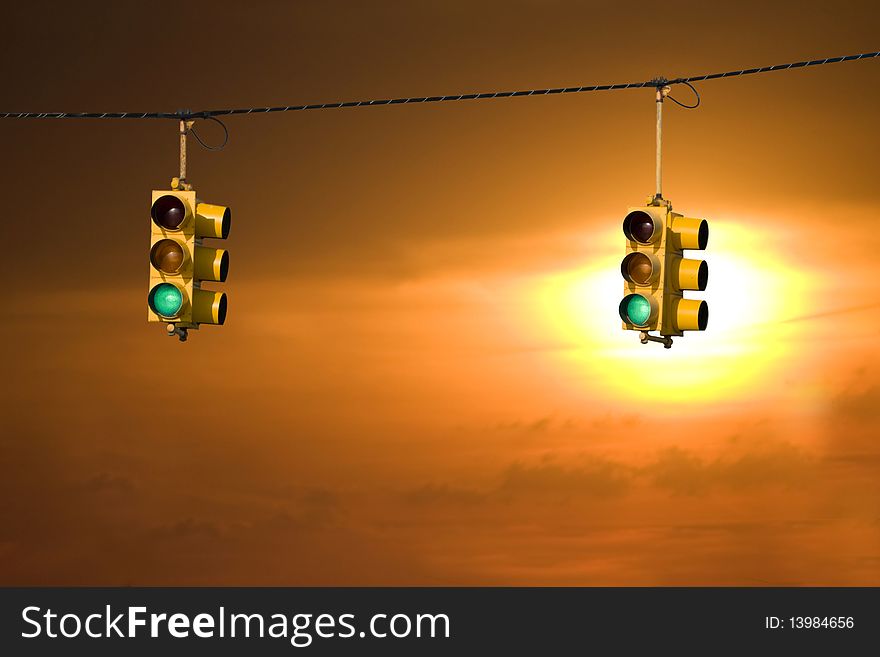 Traffic lights on green backed by a beautiful sunset. Traffic lights on green backed by a beautiful sunset.