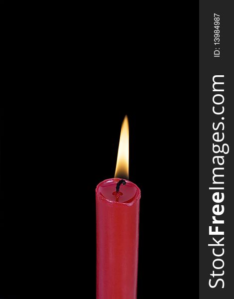 Red candle in front of black background, isolated