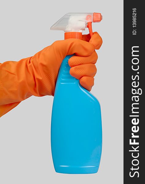 Hand with orange glove and blue spray bottle isolated with clipping path over grey background. Hand with orange glove and blue spray bottle isolated with clipping path over grey background