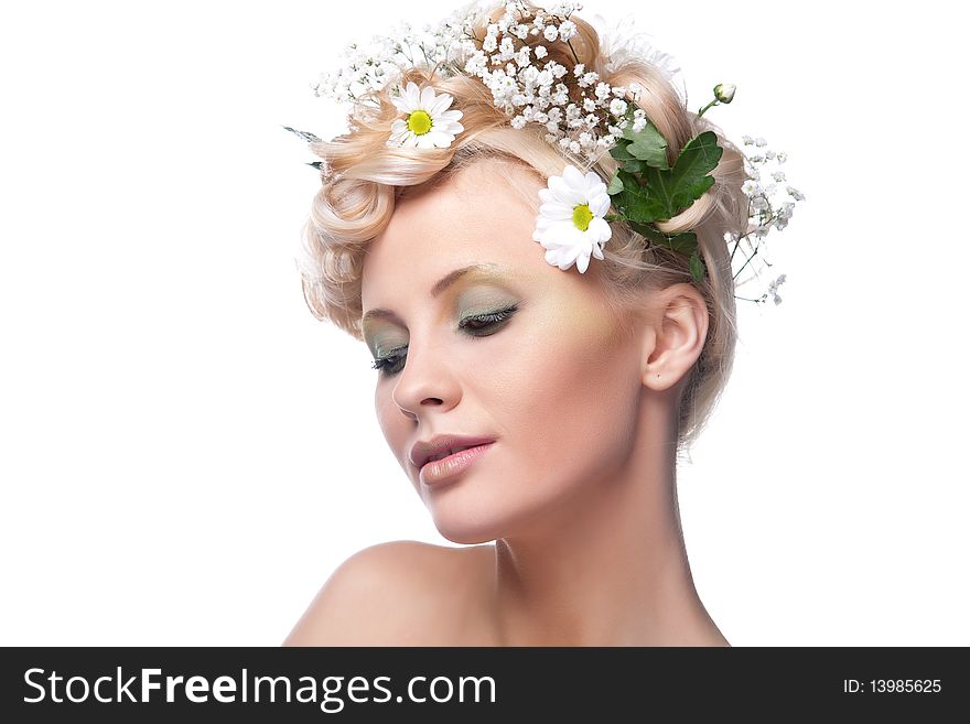 Beautiful young woman with fresh spring flowers in her hair