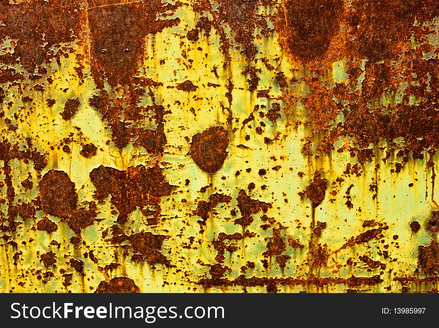 Close up of yellow paint peeling on a rusty metal door. Close up of yellow paint peeling on a rusty metal door.