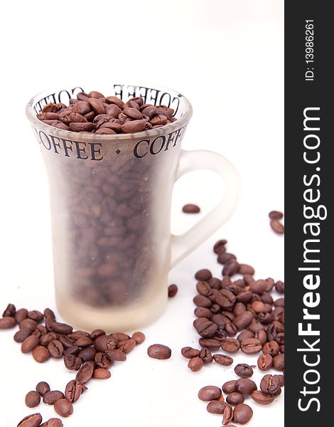 Cup with coffee beans over white background