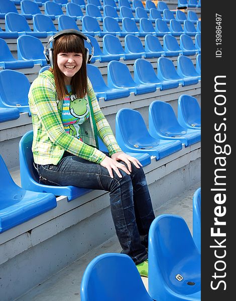 Smiling teen at the stadium with earphones