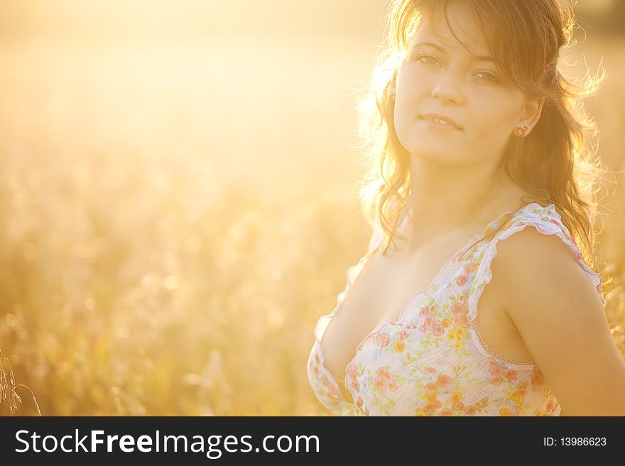 The young woman in a  dress in the field of wheat.