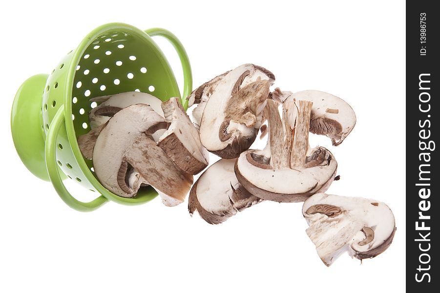 Fresh Mushroom Slices in a Vibrant Green Colander Isolated on White with a Clipping Path.