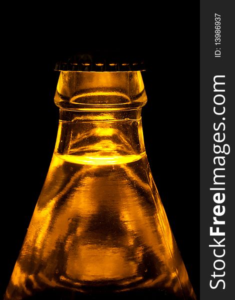 A beer bottle in a light on black