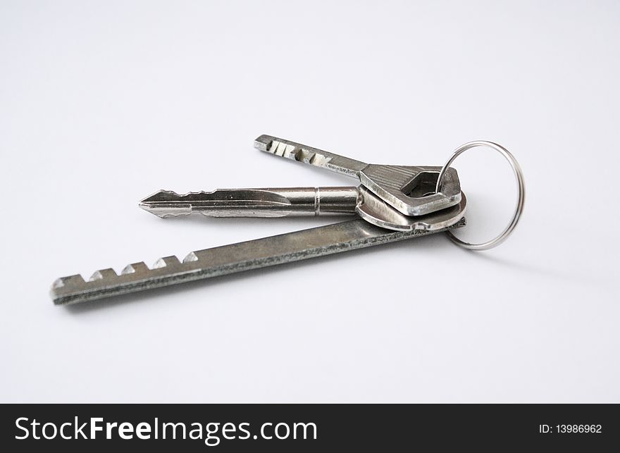 Three keys of different lengths in one ring on the table, metallichekie keys of different lengths. Three keys of different lengths in one ring on the table, metallichekie keys of different lengths