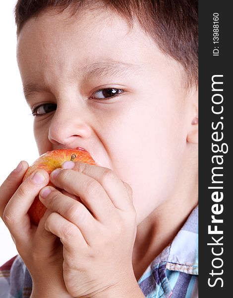 Child eating apple looking at camera over white background. Child eating apple looking at camera over white background