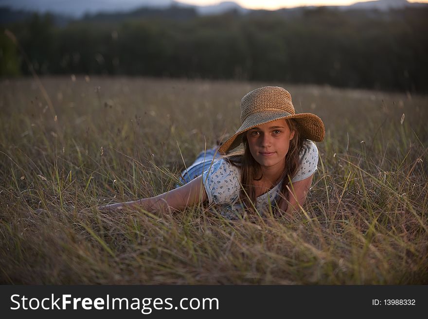 Pretty teen girl, straw hat, lying in field. Pretty teen girl, straw hat, lying in field.