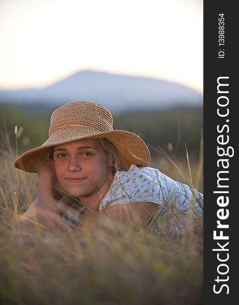 Pretty teen girl, straw hat, lying in field. Pretty teen girl, straw hat, lying in field.