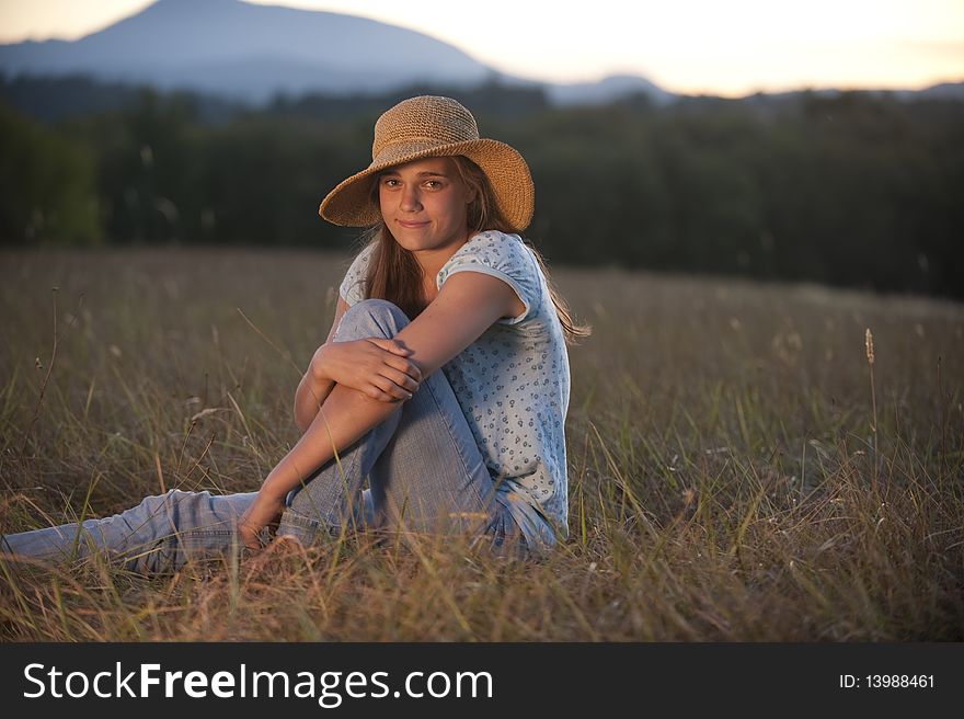 Teenage girl sitting in a field