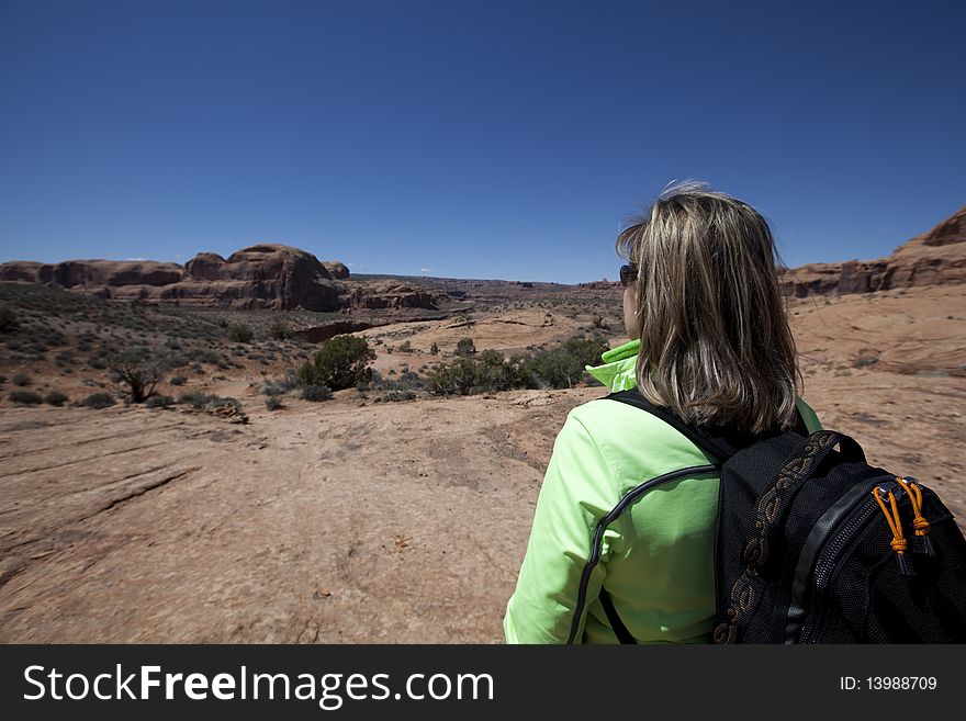Woman stops to enjoy view while hiking in Moab area. Woman stops to enjoy view while hiking in Moab area.