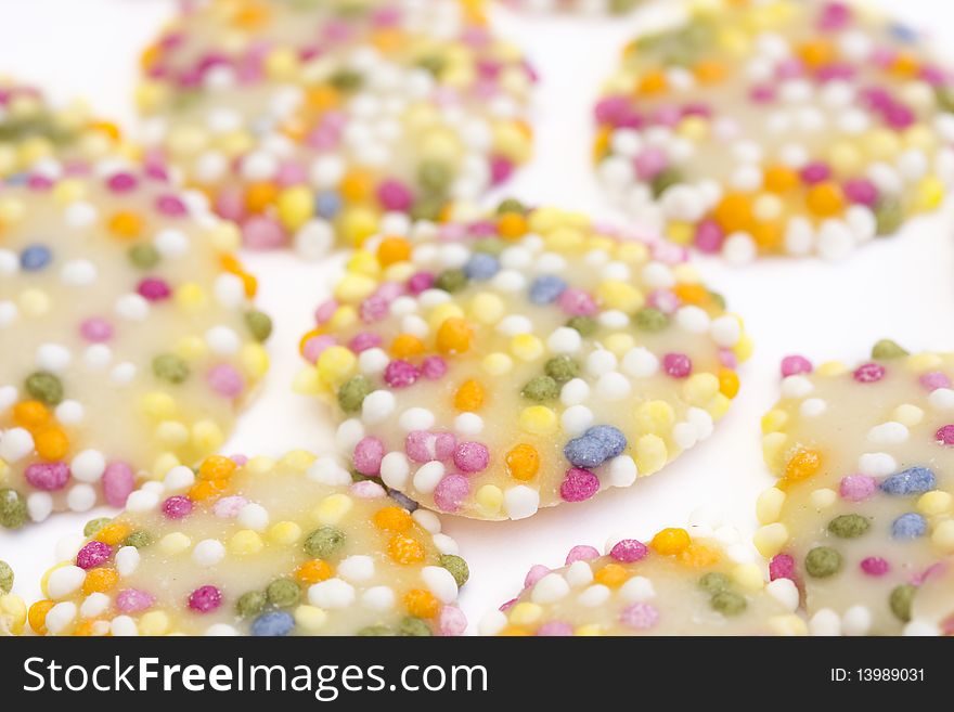 White chocolate buttons with sprinkles on a white background