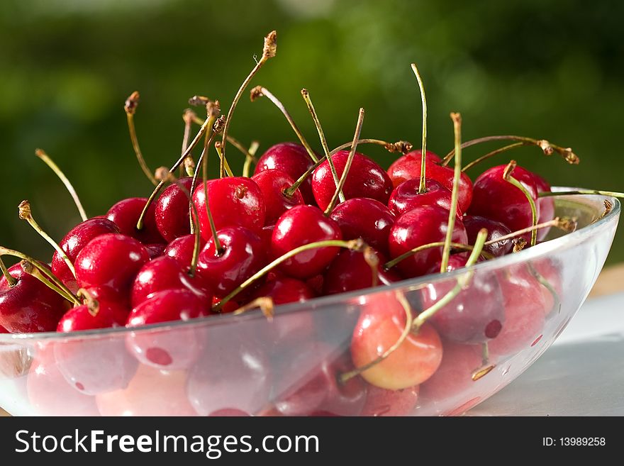 Food series: red ripe cherries on glassy plate. Food series: red ripe cherries on glassy plate