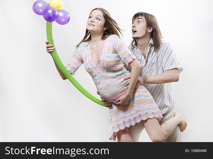 Happy flying pregnant couple holding balloon