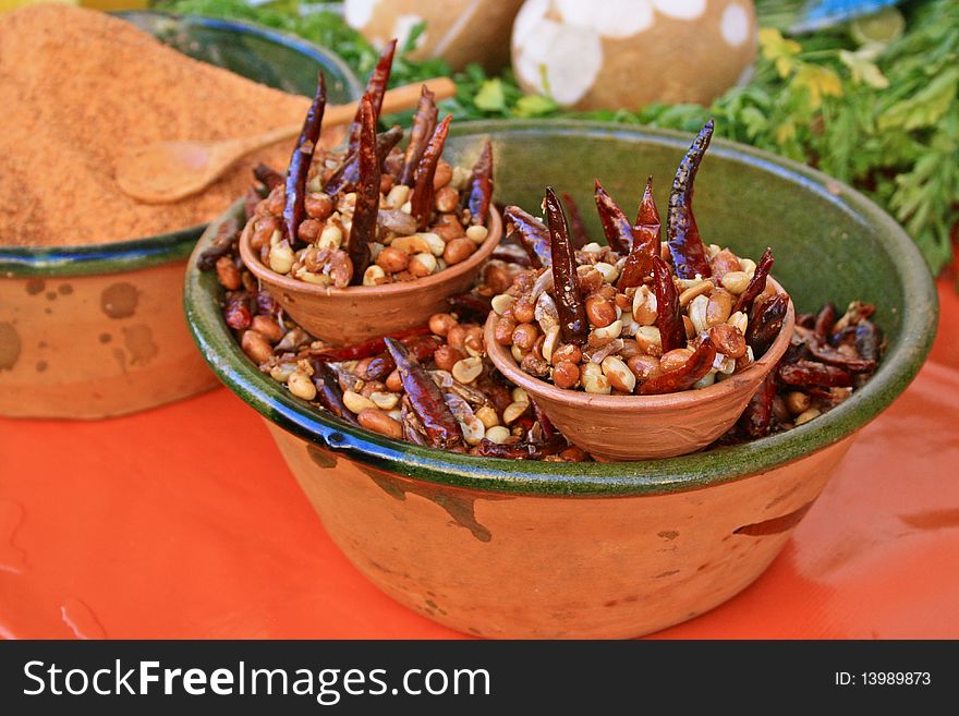 Mexican snack: Red hot Chillies and roasted peanuts presented in clay bowl