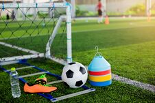 Goal, Soccer Ball, Marker Cones, Sports Shoes And Bottle Water On Green Artificial Turf Stock Image