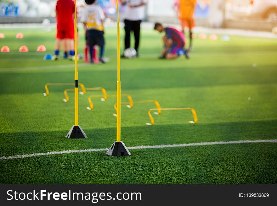 Yellow hurdles and ladder drills on green artificial turf