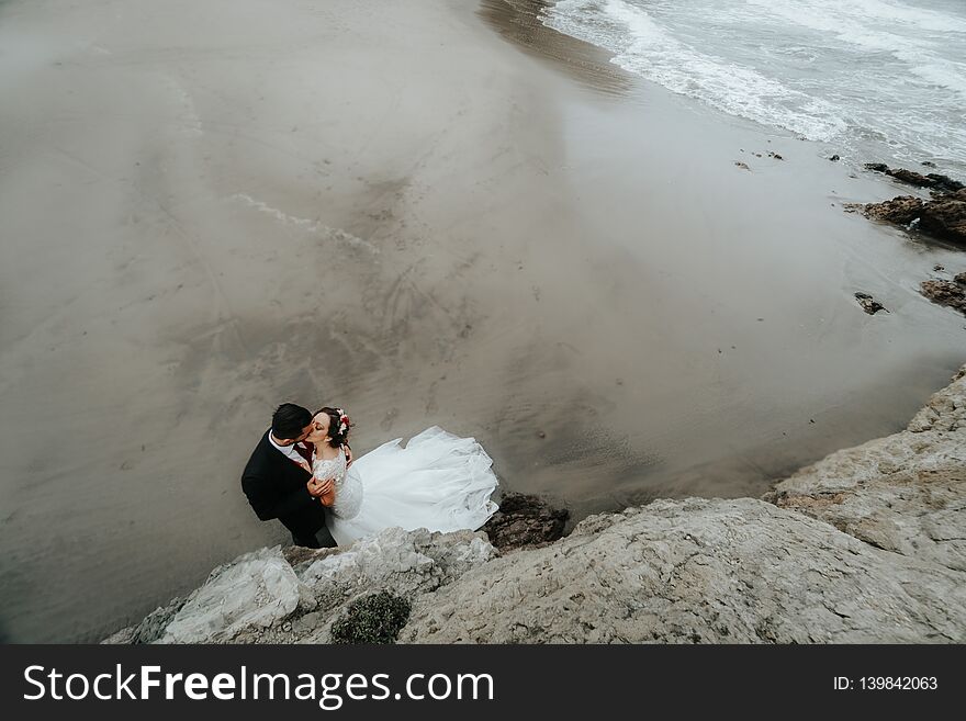 Charming wedding couple hugging on the beach. View from above