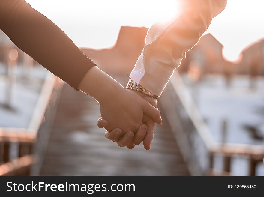 Couple Holding They`re Hands In The Sunshine