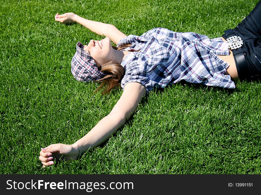 Young caucasian girl laying on the green grass. Young caucasian girl laying on the green grass