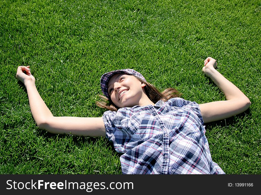 Young caucasian girl laying on the green grass. Young caucasian girl laying on the green grass