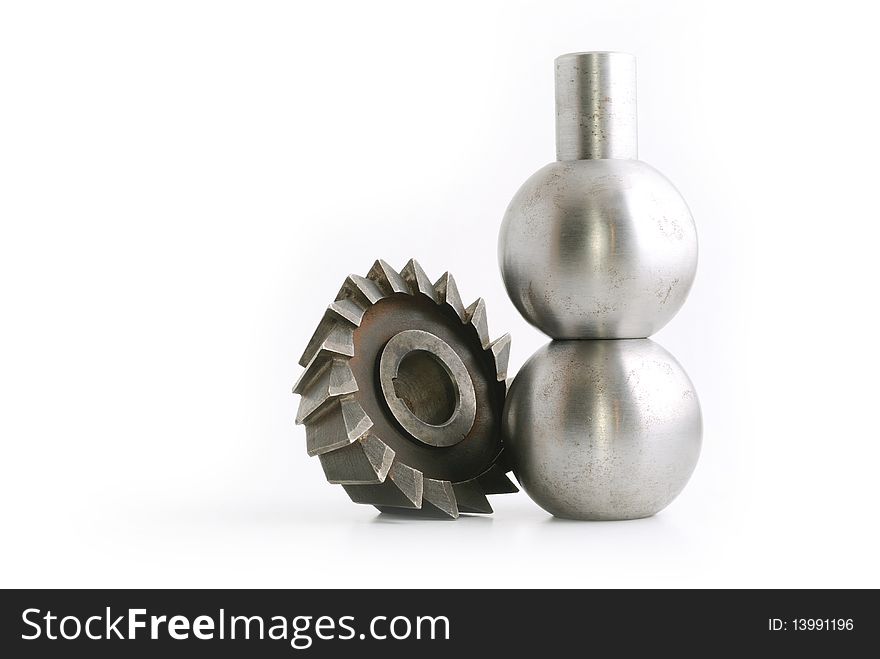 Some kind of metallic cutter, near two metallic balls sitting on eachother, isolated on white background. Some kind of metallic cutter, near two metallic balls sitting on eachother, isolated on white background